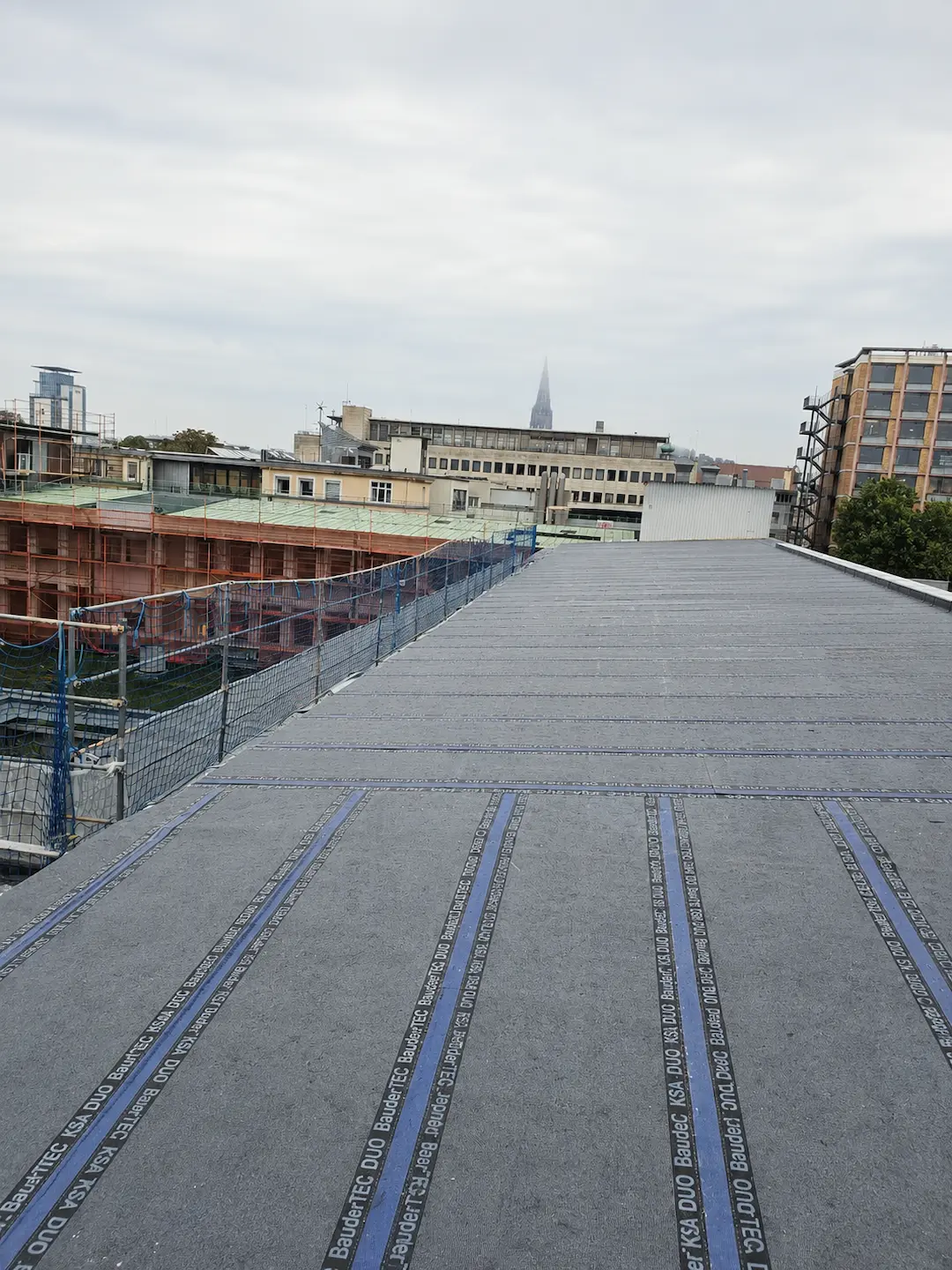 Neue Flachdachabdichtung mit Bitumenbahn auf einem Flachdach während der Dacharbeiten