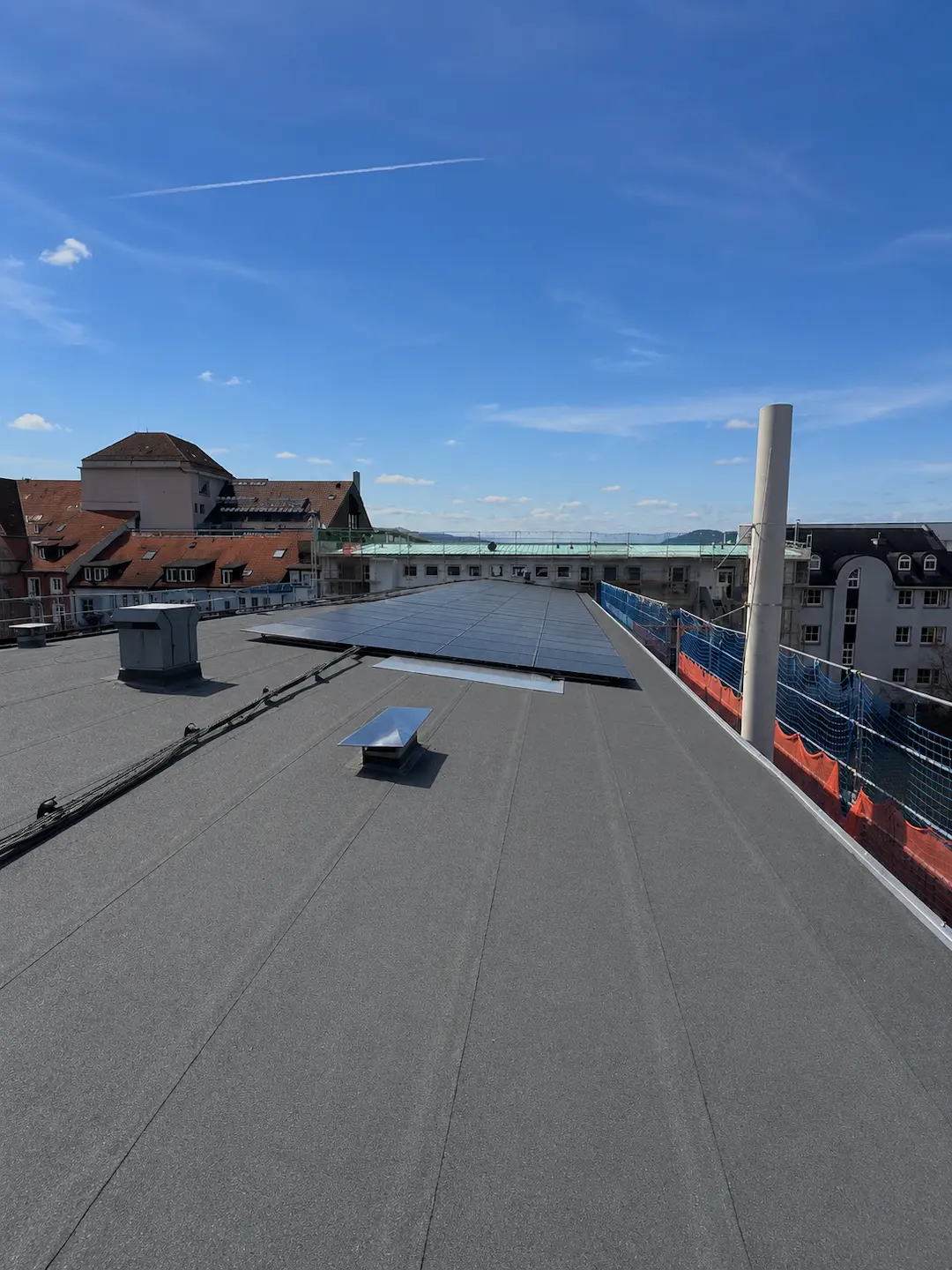 Modernes Flachdach mit Photovoltaikanlage und hochwertiger Dachabdichtung.