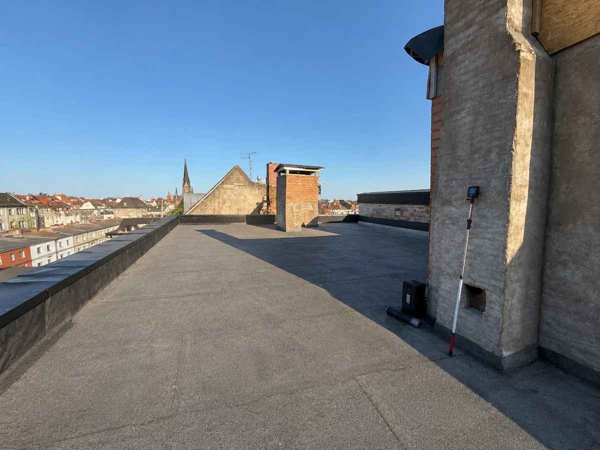 Panoramablick der Baustelle im Morgenlicht mit Kirchturm während einer Dachsanierung