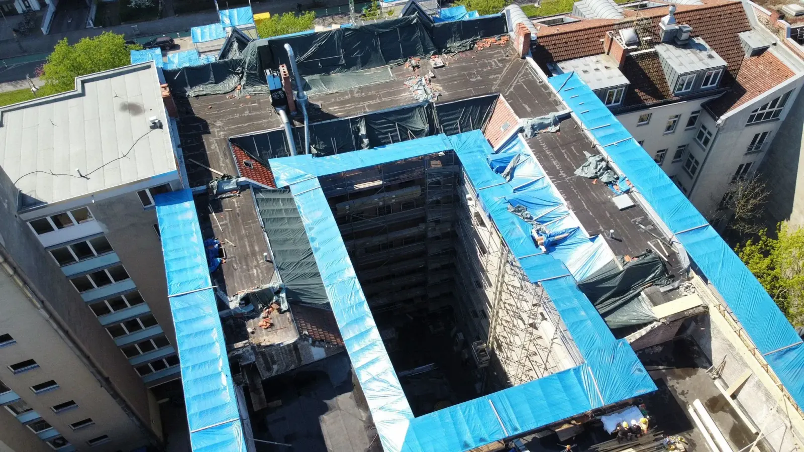Luftaufnahme der Gesamtübersicht einer Baustelle mit Wetterschutzplanen