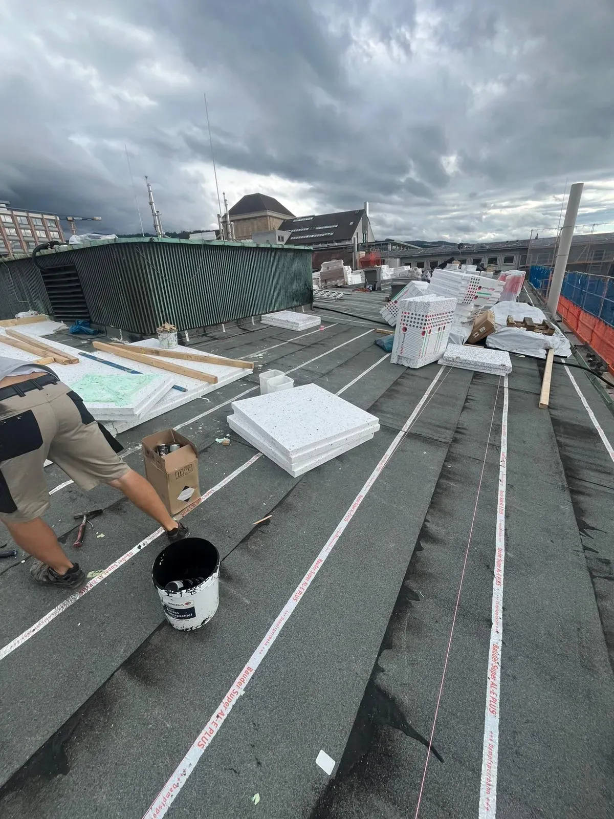 Kontrolle der Dämmplatten auf dem Flachdach bei bewölktem Himmel