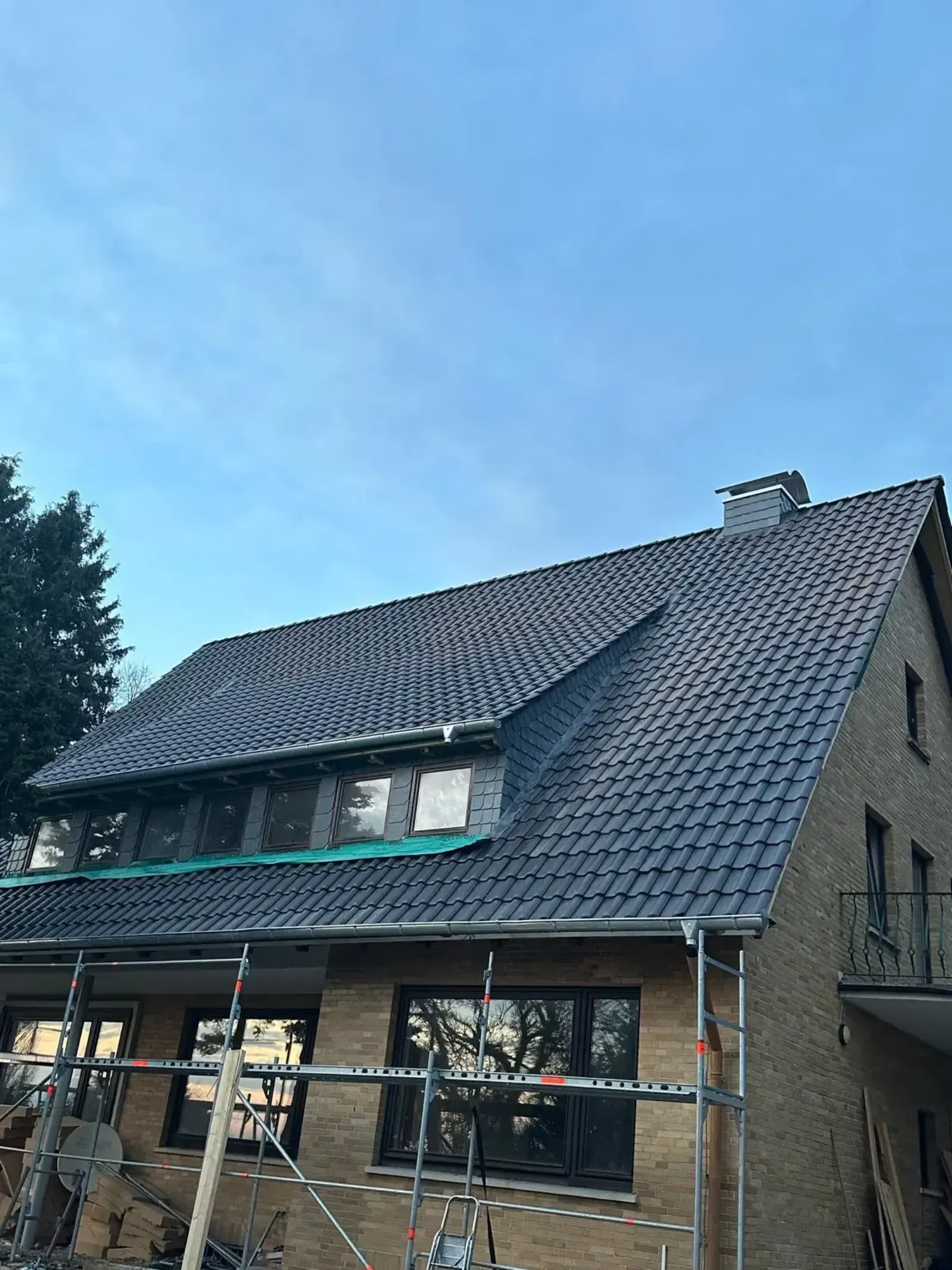 Ziegeldach eines Einfamilienhauses mit gleichmäßigem Deckbild und Klinkerfassade