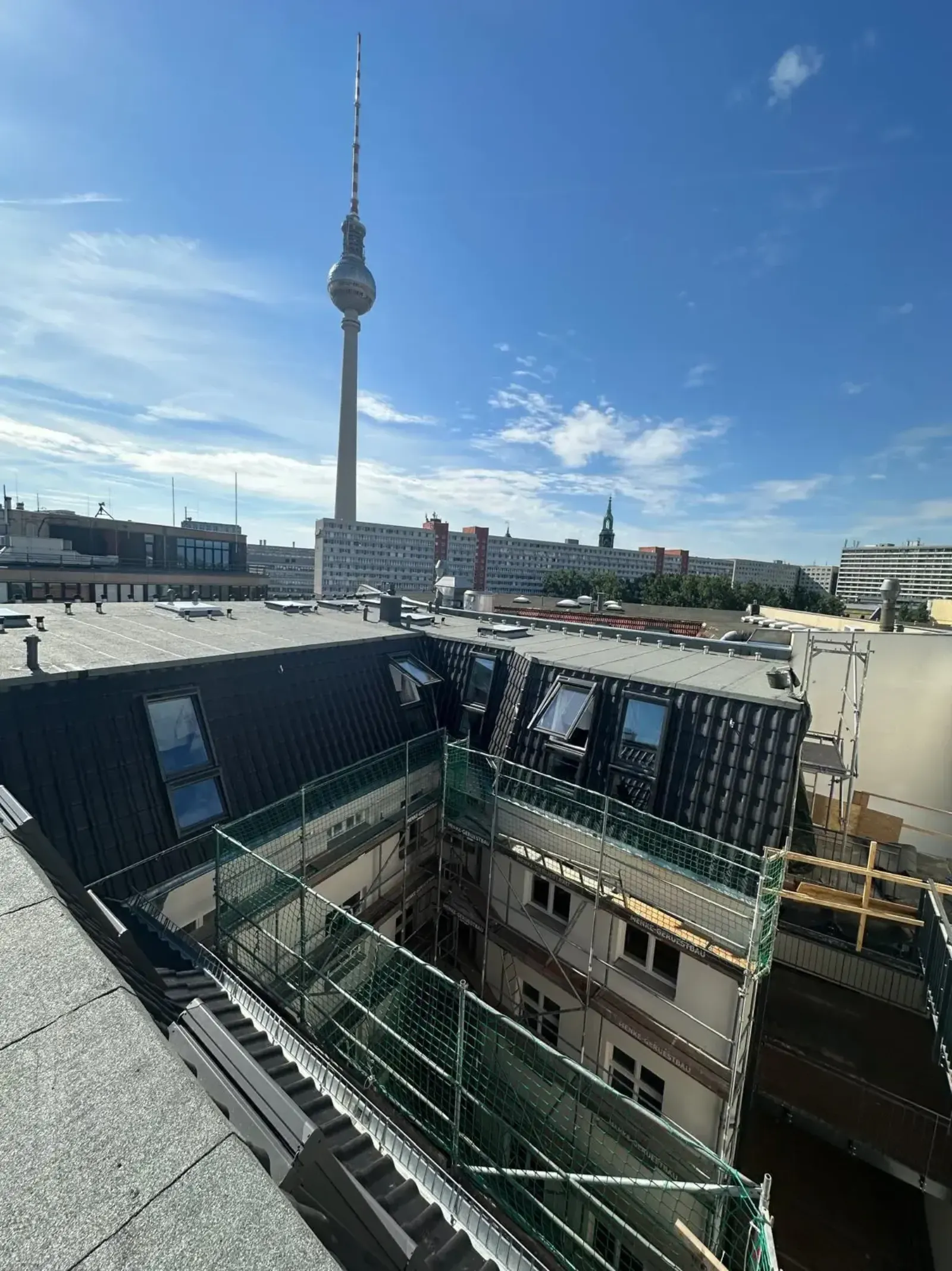 Neu eingedecktes Dach mit anthrazitfarbenen Ziegeln und VELUX-Fenstern, Berliner Fernsehturm im Hintergrund