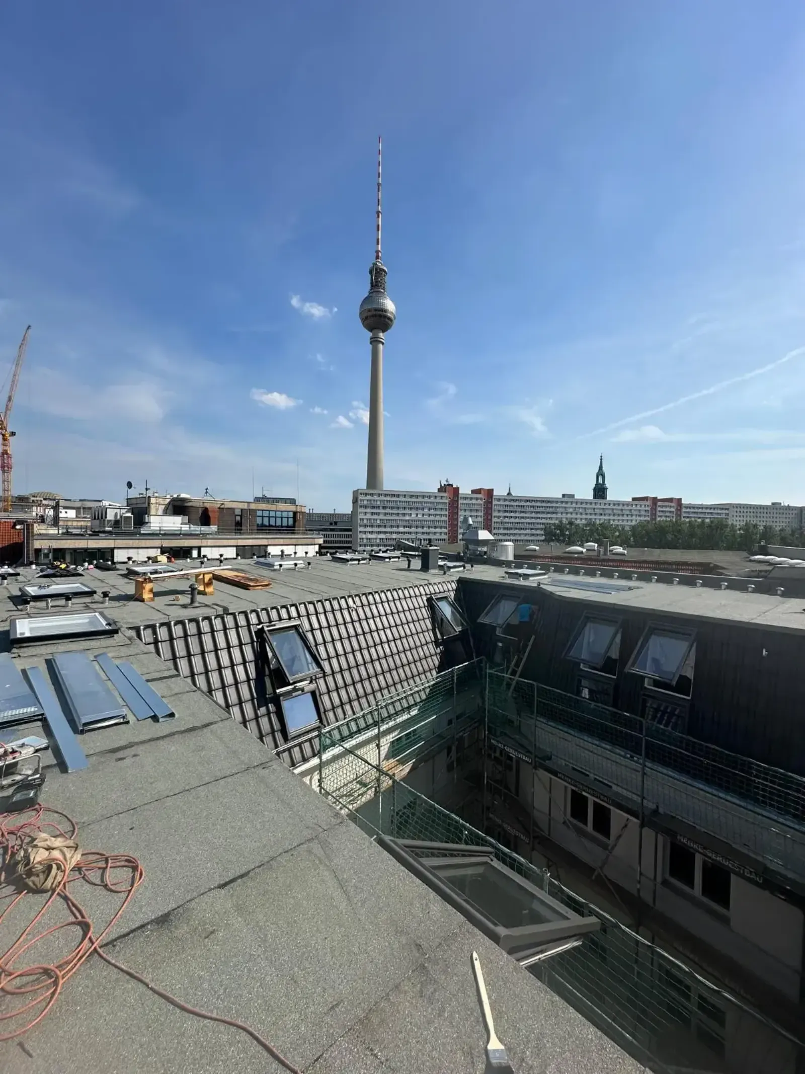 Zwischenstadium der Neueindeckung mit anthrazitfarbenen Ziegeln und VELUX-Fenstern, Fernsehturm im Hintergrund