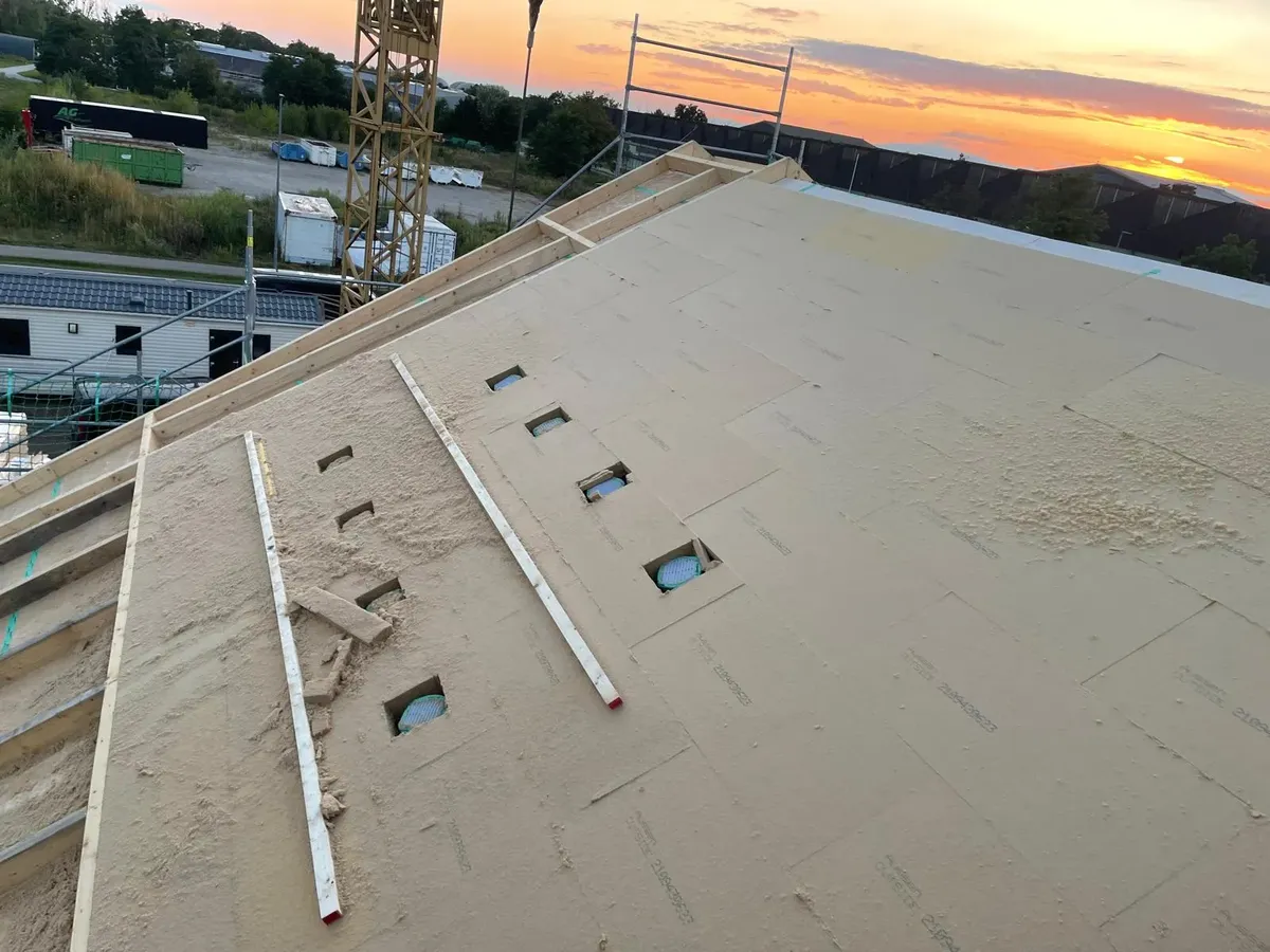 Neubauprojekt in Brandenburg mit PIR-Dämmung auf neuer Holzdachkonstruktion im Abendlicht