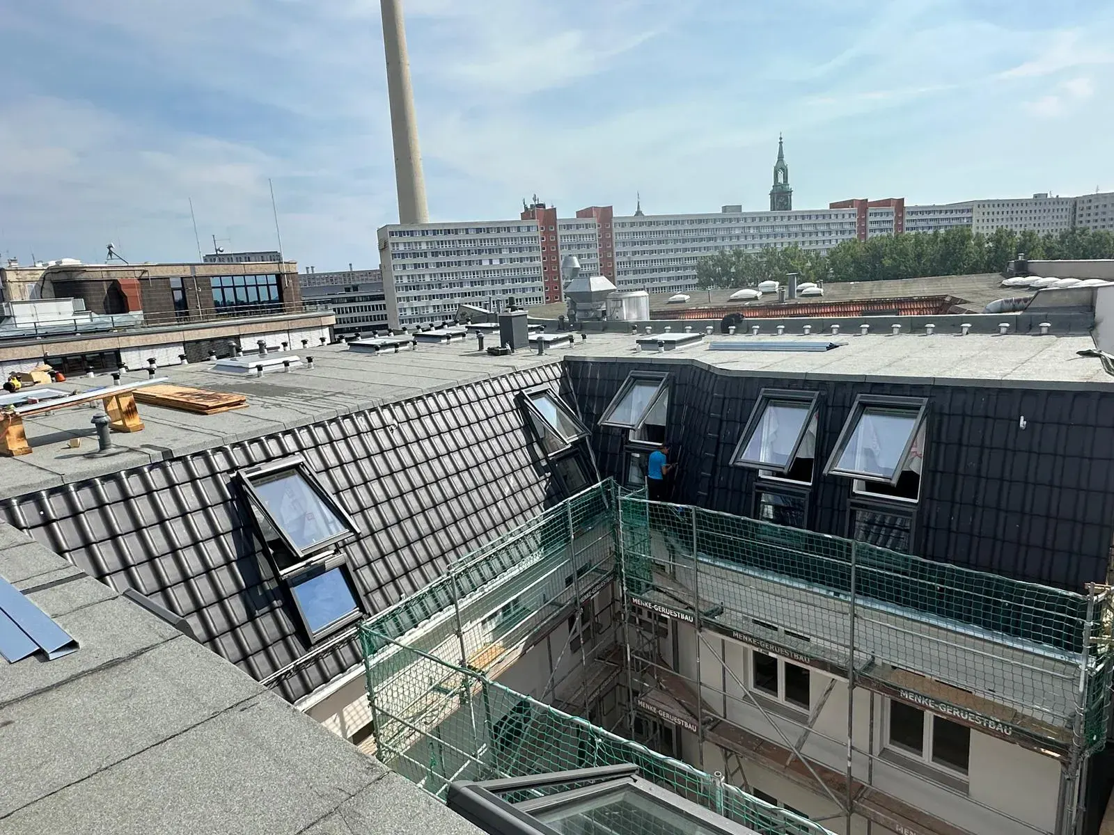 Montage von Dachgauben auf einer Ziegeldachfläche mit Blick auf Alexanderplatz und Fernsehturm