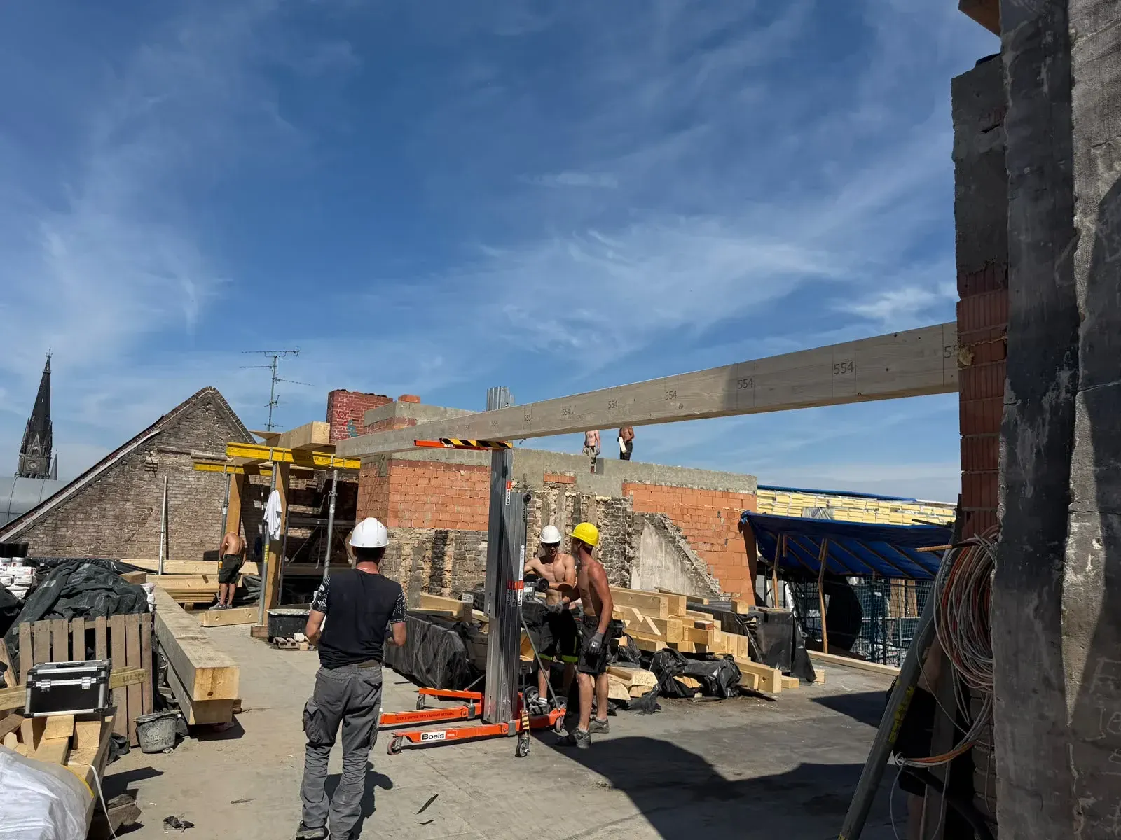 Montage schwerer Holzträger mit Kran, Berliner Kirchturm im Hintergrund
