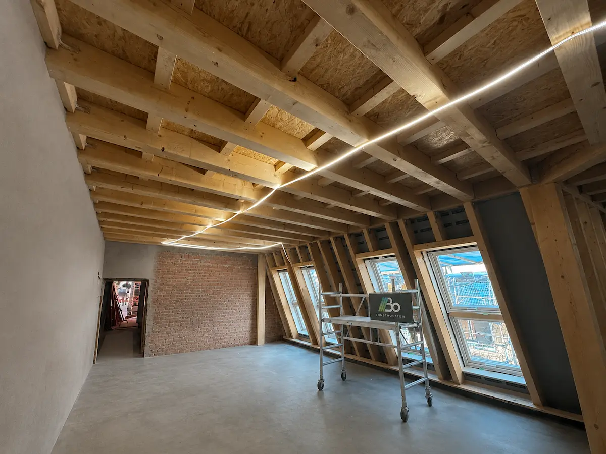 Vier Zimmerer montieren einen neuen Dachstuhl, Berliner Kirchturm im Hintergrund